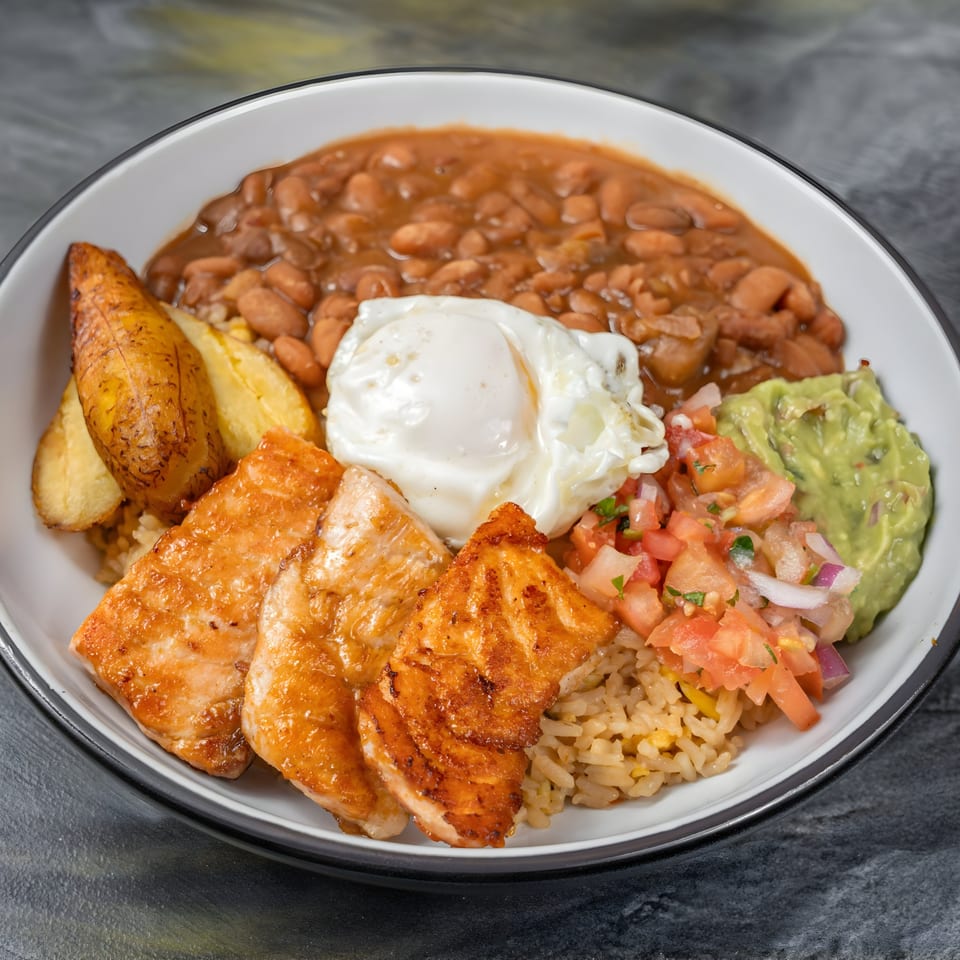 Colombian dish with salmon, rice, beans, fried plantains, guacamole, pico de gallo, and a fried egg.